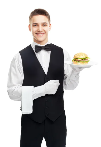 Joven camarero sonriente sosteniendo hamburguesa en el plato — Foto de Stock