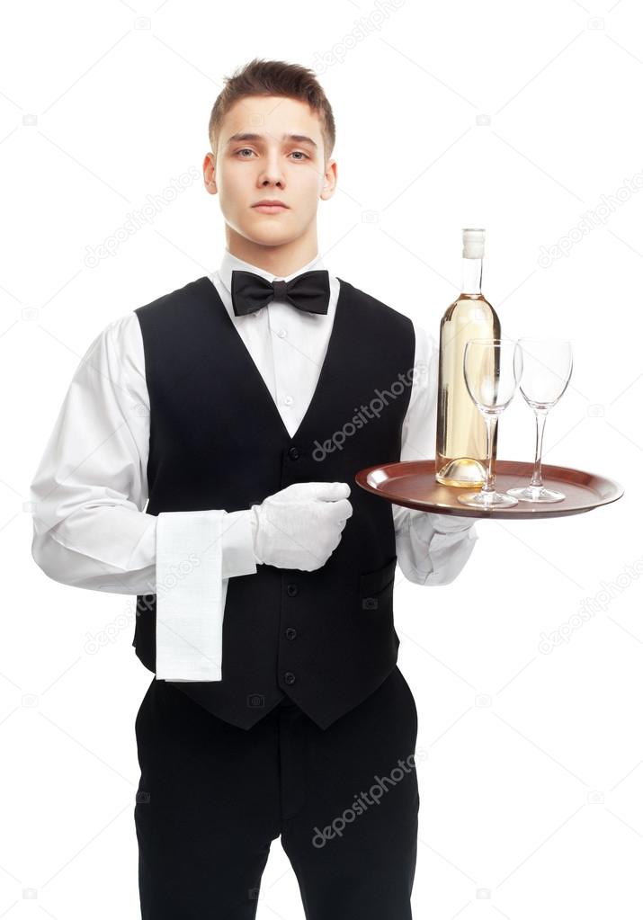 Young serious waiter with bottle of wine on tray