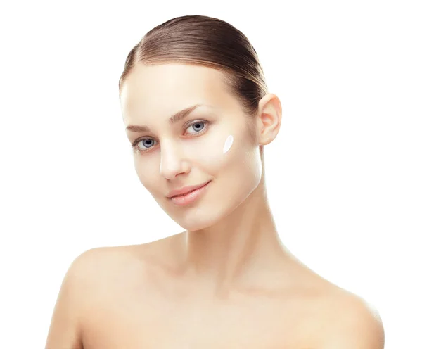 Молодая женщина с косметическим кремом на щеке — стоковое фото
