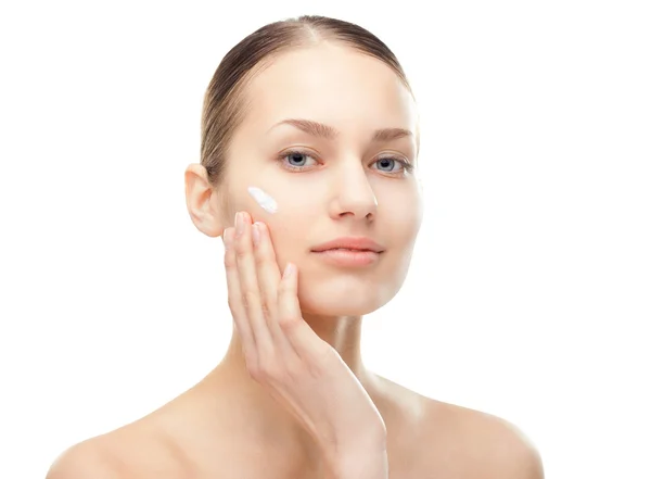Young woman with cosmetic cream on a cheek — Stock Photo, Image