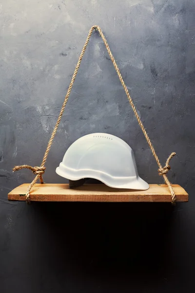 Valkoinen kypärä vanhalla puuhyllyllä — kuvapankkivalokuva