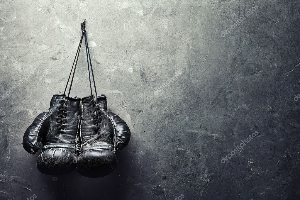 Old boxing gloves hang on nail on texture wall — Stock Photo © Gladkov
