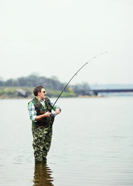 Fisherman angling on the river — Stock Photo, Image