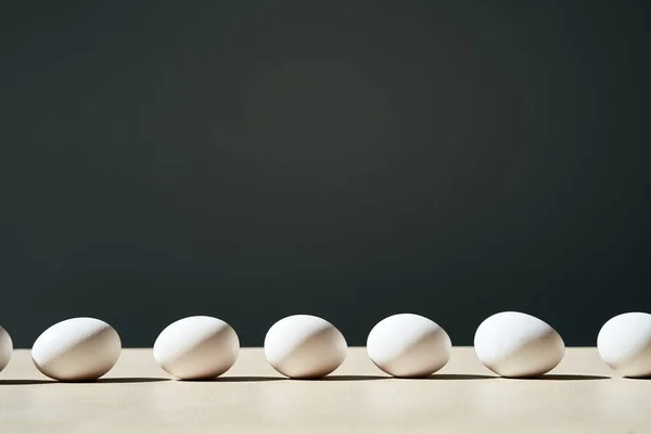 Huevos blancos en línea con el espacio de copia, concepto de minimalismo —  Fotos de Stock