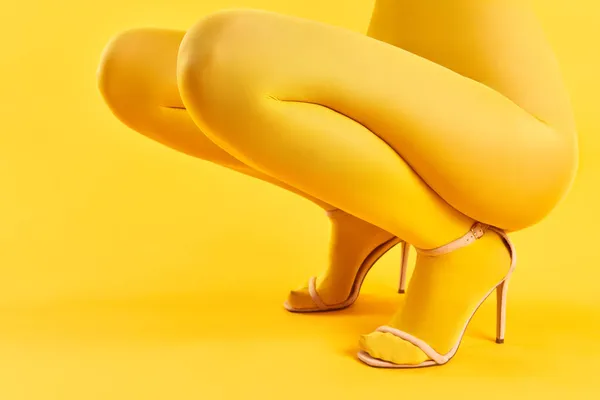 Ausgeschnittenes Porträt einer jungen Frau in gelben Strumpfhosen und stylischen High Heels — Stockfoto