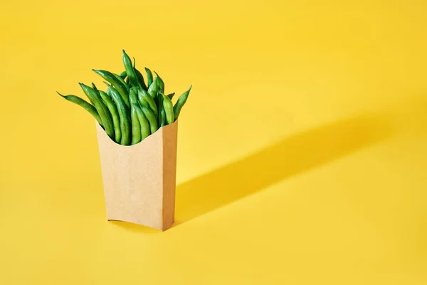 Frische grüne Bohnen in Fast-Food-Pappschachtel auf hellgelbem Hintergrund mit Kopierraum — Stockfoto