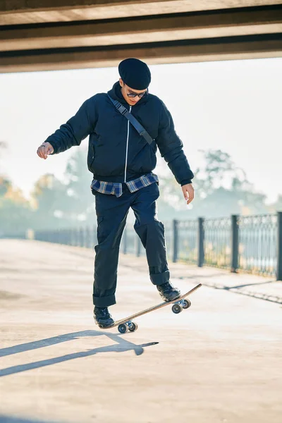 Skateboarder does ollie trick on street urban background — Foto Stock