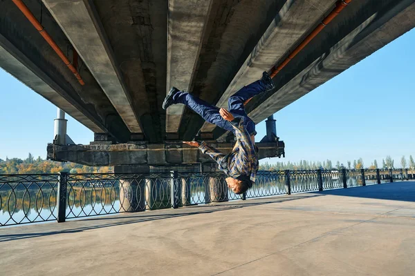 Junger Mann Break Dancer macht Purzelbäume akrobatischen Stunts tanzen auf urbanem Hintergrund — Stockfoto