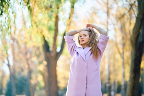 Portrait of stylish pretty woman posing outdoors in autumn park enjoying sunny day — ストック写真