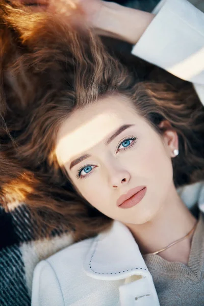 Nahaufnahme Porträt einer hübschen jungen Frau mit langen welligen Haaren im Sonnenlicht im Freien — Stockfoto