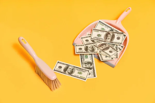 Creative layout with dustpan, hand brooms and money dollar bills on red background — Stock Photo, Image