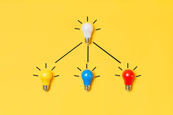 Kreatív elrendezés többszínű villanykörték sárga alapon. — Stock Fotó