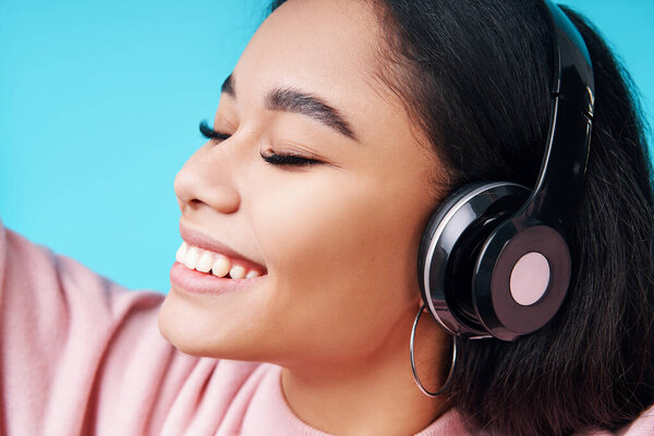 Close up portrait of pretty young woman listening music with her headphones Royalty Free Stock Images