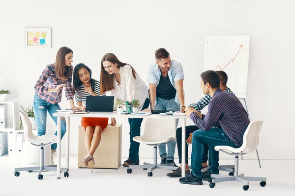 Smiling diverse group of young people working and communicating together in office — Foto de Stock