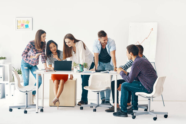 Smiling diverse group of young people working and communicating together in office Royalty Free Stock Images