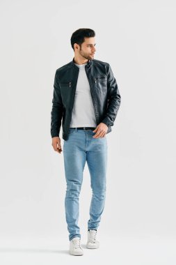 Beyaz stüdyo arka planında yürüyen yakışıklı şık bir adam.