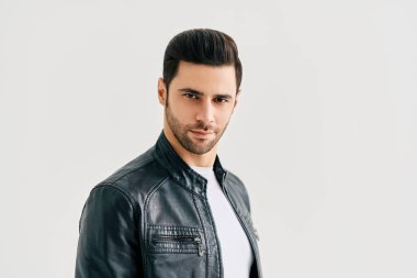 Beyaz stüdyo arka planında poz veren yakışıklı adamın yakın plan portresi.