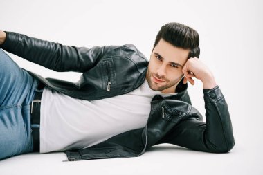 Beyaz stüdyo arka planında yerde yatan yakışıklı şık bir adam..