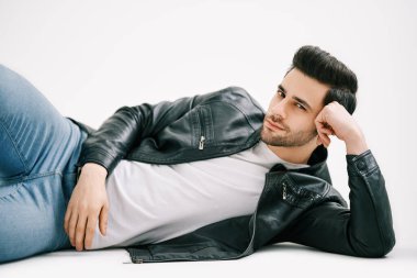 Beyaz stüdyo arka planında yerde yatan yakışıklı şık bir adam..