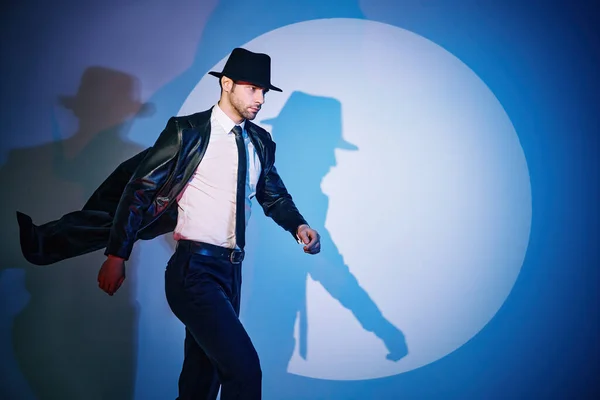 Красивый мужчина в черном пальто и шляпе ходит как супергерой в центре внимания — стоковое фото