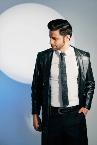 Handsome trendy man posing in the spotlight on studio background — Foto de Stock