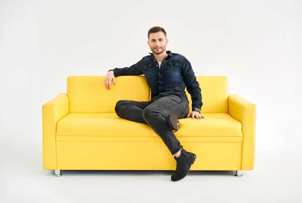 Young Trendy Man Posing Sitting Yellow Sofa Looking Camera Relax — Stock Photo, Image