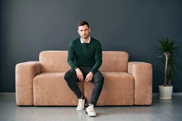 Joven Hombre Moda Posando Sentado Sofá Mirando Cámara Concepto Relajación —  Fotos de Stock