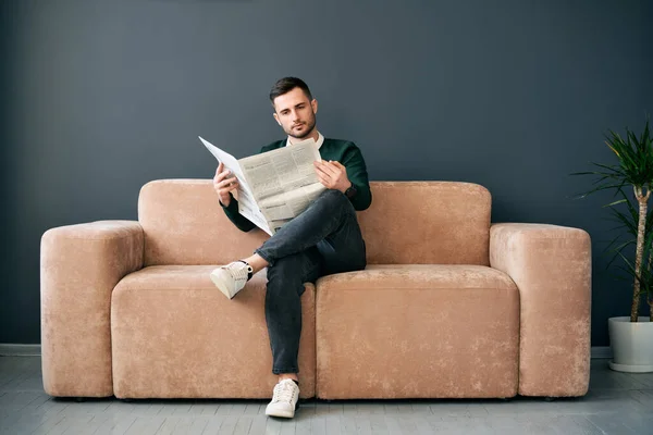 Confident Young Man Reading Newspaper Latest News While Sitting Sofa — Stock Fotó