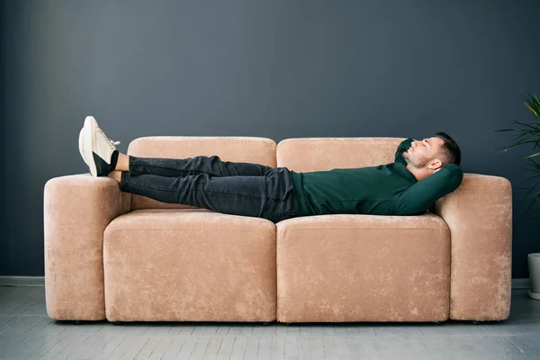 Young Trendy Man Relaxing Alone Textile Sofa Home Rest Concept — Zdjęcie stockowe