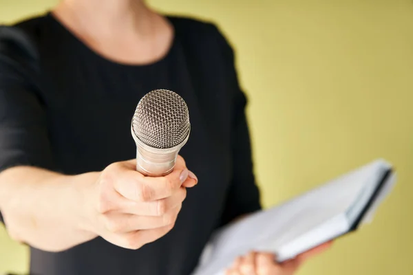 Journalist with microphone interviewing you. Cropped image of female reporter holding microphone to camera, Focus on microphone. journalism, broadcasting, News conference concept