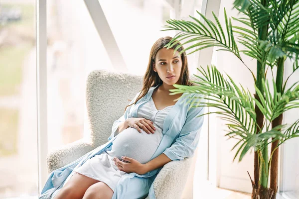 Těhotná Šťastná Žena Dotýkající Břicha Odpočívá Židli Moderním Domě Něžná — Stock fotografie