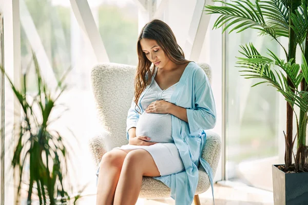 Těhotná Šťastná Žena Dotýkající Břicha Odpočívá Židli Moderním Domě Něžná — Stock fotografie