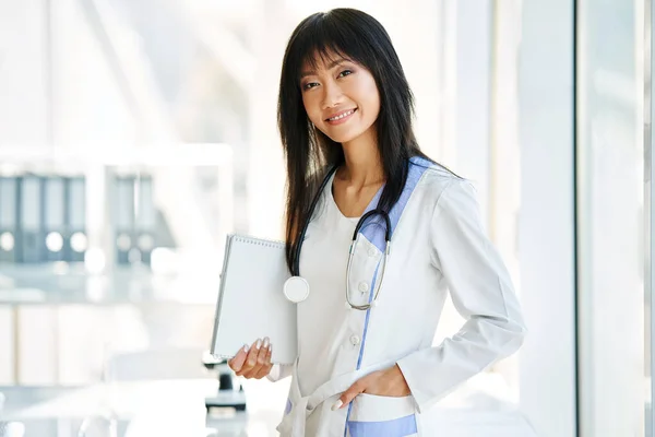 Sonriente Doctora Confiada Sosteniendo Portapapeles Posando Hospital Medicina Profesión Concepto —  Fotos de Stock