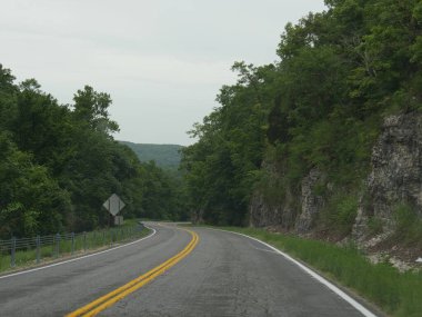 Yol boyunca kaya duvarları olan dolambaçlı bir yol.
