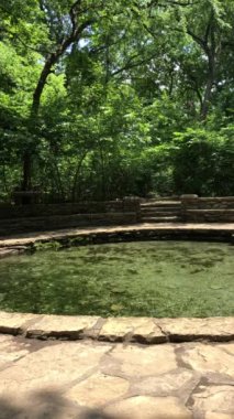 Yeraltı kaynağından gelen yuvarlak bir havuzda kaynayan su, dikey şarjör.