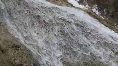 Şelaledeki büyük bir kayanın yüzeyinden sürekli akan su görüntüsü.