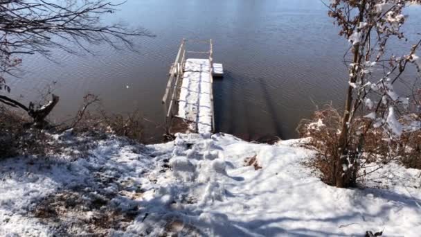 湖で雪に覆われた木製のドックの手持ち撮影 — ストック動画