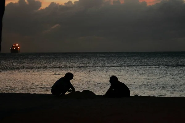 Silhouette Két Fiú Játszik Homokban Naplementekor — Stock Fotó
