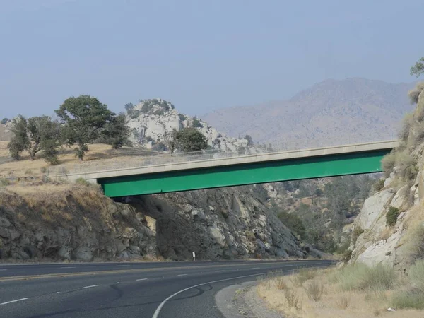 Ponte Sobre Uma Estrada Sinuosa Com Montanhas Distância Longo Estrada — Fotografia de Stock