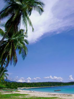 Muhteşem bulutları ve mavi suları olan güzel bir plajın portresi, Davao Oriental, Filipinler.