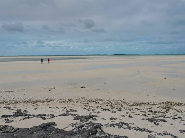 Dalgalar alçaldığında panoramik beyaz kum uzantısı, Exuma Point Sahili, Bahamalar.