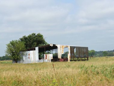 Açık bir çiftlik arazisindeki harap olmuş bir ahırın orta ölçekli kapatılması.