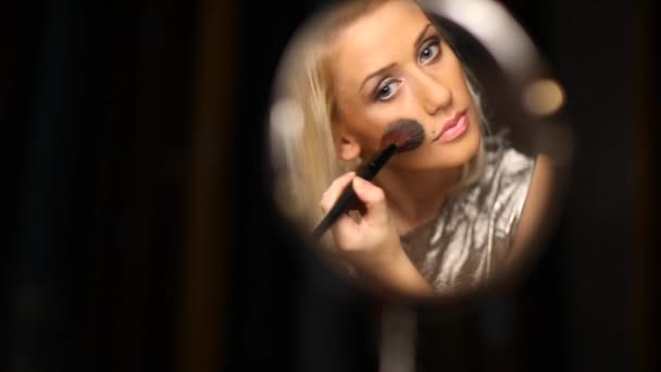 Блондинка одягає рум'яна у дзеркало — стокове відео