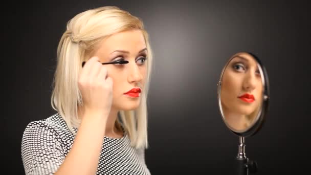 Belle mannequin blonde portant un mascara dans le miroir — Video