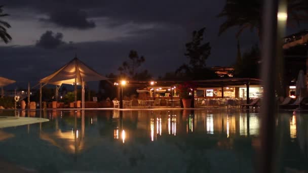 Brightly lit hotel pool at night — Stock Video