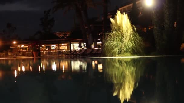 Szálloda fényesen kivilágított medence éjjel — Stock videók