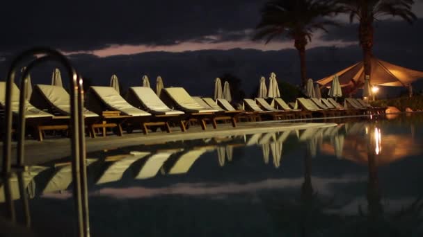 Csodálatos szálloda fényesen kivilágított medence éjjel — Stock videók