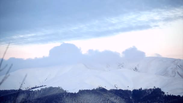 冬天的月亮上升和云被雪封住的山顶上的 timelapse — 图库视频影像