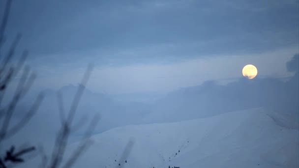 冬月の上昇と雪に覆われた山の頂上に雲のタイムラプス — ストック動画