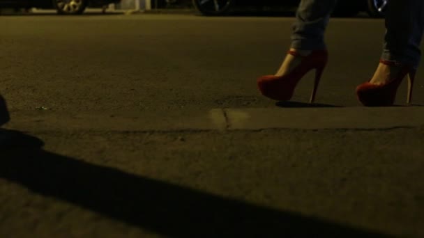 Zapatos rojos abajo calle oscura — Vídeo de stock